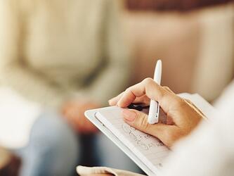 someone taking notes as part of therapy session